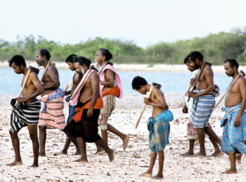 Veddahs walk along the Vakarai beach